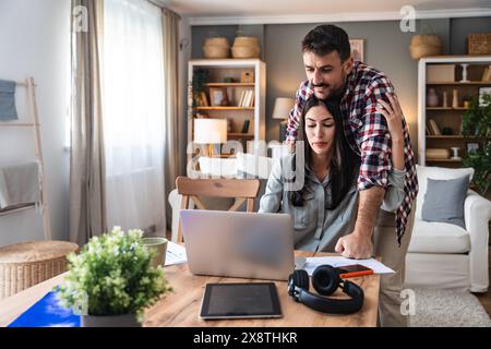 Jeune couple, freelancers propriétaires de petites entreprises Internet, concepteurs professionnels, développeurs de logiciels informatiques, travaillant ensemble à la maison, sur de nouveaux proje Banque D'Images