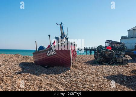 Bateau de pêche sur une plage de galets avec casiers à homard. Bognor Regis, Sussex, Royaume-Uni Banque D'Images