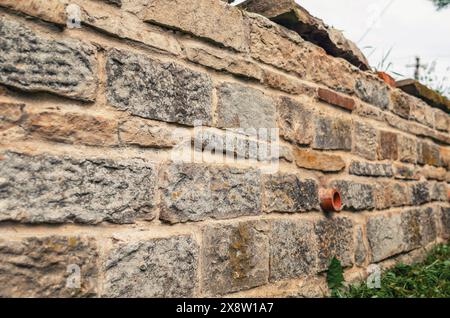 petit mur en pierre naturelle, fondation avec tube d'eau Banque D'Images