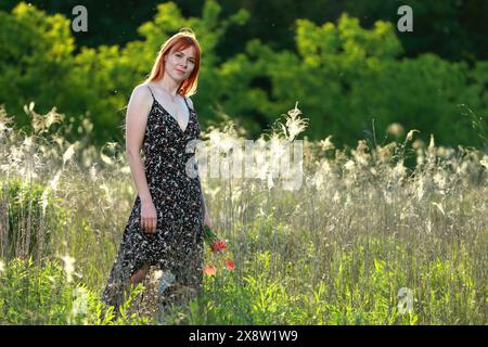 Une fille pose devant la caméra dans la nature. Joie, bonheur, sérénité. Banque D'Images