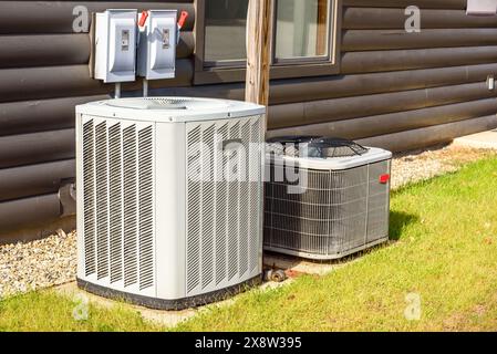 Unités externes du système de chauffage et de climatisation sur l'herbe dans une cour arrière de maison Banque D'Images