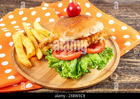 Hamburger de poulet savoureux frais sur la table en bois. Hamburger au poulet. Sandwich avec hamburger de poulet, tomates, fromage et laitue. Cheeseburger. Banque D'Images