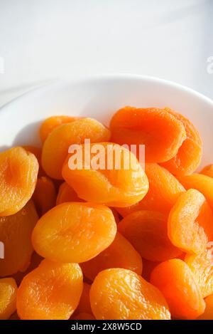 Fruits secs. Abricots séchés. Abricots séchés en gros plan sur une assiette blanche. Banque D'Images