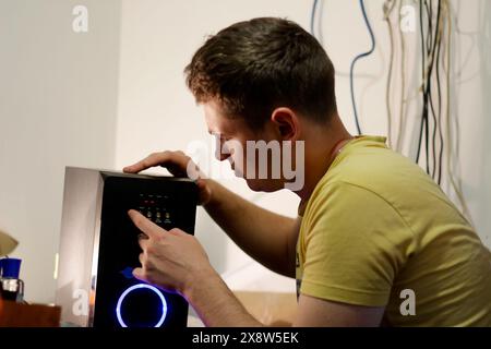 Jeune ingénieur réparant un système hi-fi musical. homme réparant instrument de musique, atelier d'ingénieur audio, entretien professionnel. EQUIPEMENT musical Banque D'Images