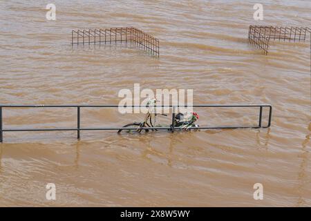 Promenade inondée le long du Rhin à Cologne en Allemagne avec un vélo oublié sur une rampe Banque D'Images