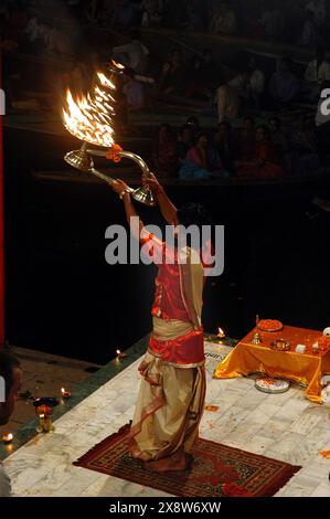 Ganga Arati - une activité rituelle dédiée au holi Ganga. Benaras est considérée comme la capitale culturelle des villes les plus anciennes et les plus saintes de l'Inde et abrite les ghats les plus célèbres (150 marches menant à la rivière) du pays. Des foules énormes de pèlerins et de visiteurs de toutes les parties du monde se rassemblent pour prendre part à cet ancien rituel qui consiste à faire des offrandes (puja) au soleil levant. Benaras a été un centre traditionnel d'apprentissage de la philosophie, du sanskrit, de l'astrologie et de la religion. Benaras, Uttar Pradesh, Inde. Banque D'Images