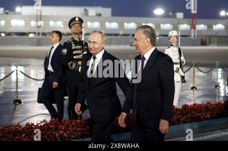 Tachkent, Ouzbékistan. 26 mai 2024. Le président ouzbek Shavkat Mirziyoyev, à droite, escorte le président russe Vladimir Poutine, à gauche, à son arrivée pour une visite de deux jours à l'aéroport international Islam Karimov Tachkent, le 26 mai 2024, à Tachkent, Ouzbékistan. Crédit : Mikhail Metzel/Kremlin Pool/Alamy Live News Banque D'Images