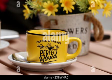 Une tasse à café jaune vif se trouve sur une table extérieure, Cadix, Espagne Banque D'Images
