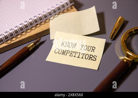 CONNAISSEZ VOS CONCURRENTS texte dans le carnet de bureau avec clavier, loupe et lunettes, concept d'affaires Banque D'Images