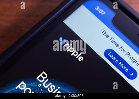 Logo de Ripple vu dans un iPhone. Ripple (XRP) est un protocole de paiement numérique et crypto-monnaie qui vise à faciliter les transferts d'argent internationaux Banque D'Images