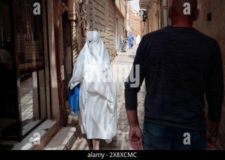 Femme mozabite en haik blanc marchant dans la rue de Ksar Ghardaia. Ghardaia Province.northern Sahara. Algérie Banque D'Images