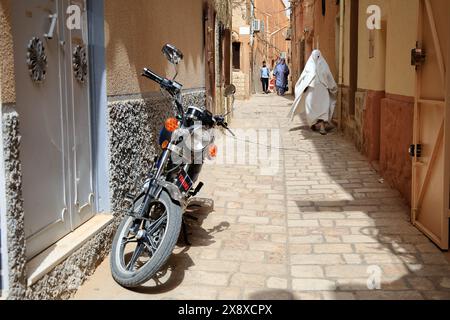 Femme mozabite en haik blanc marchant dans la rue de Ksar Ghardaia. Ghardaia Province.northern Sahara. Algérie Banque D'Images