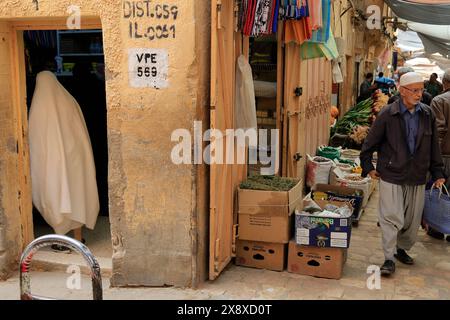 Une femme mozabite voilée dans des achats de haik blanc dans un magasin de fournitures ménagers au marché de Ghardaia. Vallée de Mzab. Province de Ghardaia. Sahara du Nord. Algérie Banque D'Images