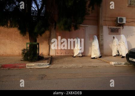 Femmes mozabites voilées en haik blanc marchant à l'extérieur de Ksar El Atteuf. Vallée de Mzab. Province de Ghardaia. Sahara du Nord. Algérie Banque D'Images