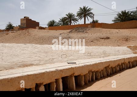 Un homme regardant le puits du réservoir d'eau souterrain du système traditionnel de distribution et de gestion des eaux d'inondation à Ghardaia. Vallée de Mzab. Ghardaia Province.north Sahara. Algérie Banque D'Images