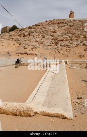 Un homme regardant le puits du réservoir d'eau souterrain du système traditionnel de distribution et de gestion des eaux d'inondation à Ghardaia. Vallée de Mzab. Ghardaia Province.north Sahara. Algérie Banque D'Images