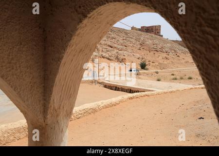 Un homme regardant le puits du réservoir d'eau souterrain du système traditionnel de distribution et de gestion des eaux d'inondation à Ghardaia. Vallée de Mzab. Ghardaia Province.north Sahara. Algérie Banque D'Images