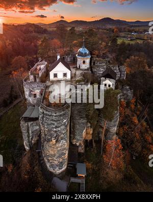 Sloup v Cechach, République tchèque - vue aérienne du château de Rock Sloup en Bohême du Nord avec un coucher de soleil coloré spectaculaire, nuages, ciel bleu et automne fo Banque D'Images