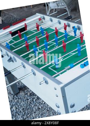 Cremona, Italie - 15 mai 2024 en gros plan d'un match compétitif de baby-foot avec des joueurs rouges et bleus. Figurines en plastique. Tiges métalliques. Et manuelle Banque D'Images