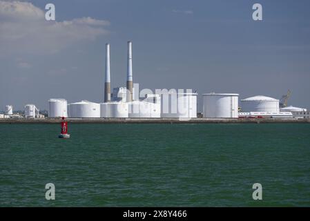 Le Havre, France - vue sur les réservoirs de stockage du terminal pétrolier du port du Havre avec la centrale thermique du Havre en arrière-plan. Banque D'Images