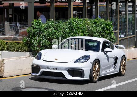 Monte Carlo, Monaco - vue sur une Porsche 718 Cayman GT4 blanche conduisant dans une rue. Banque D'Images