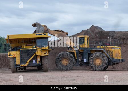 Raon-l'étape, France - vue sur une chargeuse sur pneus jaune KOMATSU WA800-3 chargement d'un camion à benne basculante KOMATSU HD785-7 dans une carrière de pierre. Banque D'Images