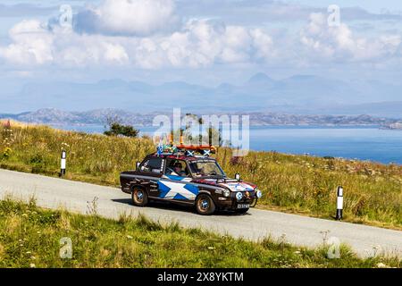 Royaume-Uni, Écosse, Highlands, île de Skye, péninsule de Trotternish, Old Man of Storr, voiture avec drapeau écossais participant au Scotland Rally Banque D'Images