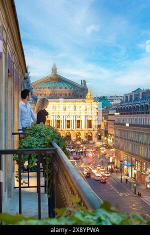 France, Paris, avenue de l'Opéra, amoureux sur le balcon de leur suite à l'hôtel Edouard 7 avec Opéra Garnier (construit en 1875) en toile de fond Banque D'Images