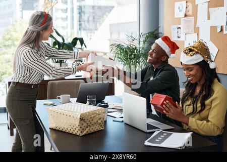 Heureux, les gens d'affaires et donner cadeau de Noël en réunion pour le team building et la collaboration dans le bureau. Groupe d'entreprise et boîte de Noël à l'entreprise Banque D'Images