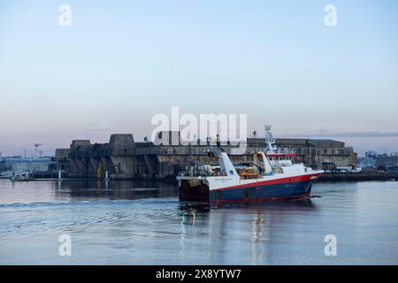 France, Morbihan, Lorient, le port à l'aube avec un chalutier devant l'ancienne base sous-marine Keroman Banque D'Images