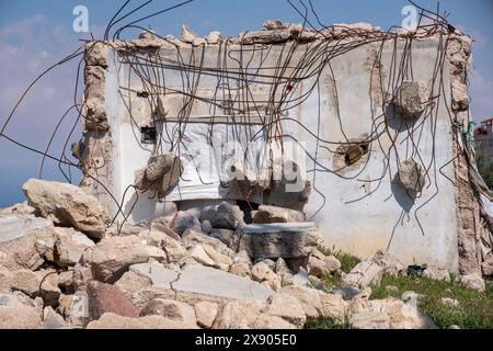 Bâtiment en ruine. Un tas de béton, de gravats et de débris d'armature au milieu d'un lieu urbain représente les vieilles maisons qui peuvent s'effondrer à tout moment Banque D'Images