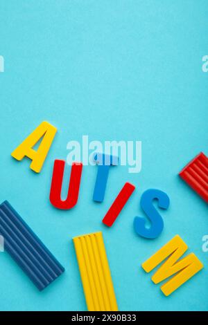 Autisme. Trouble du spectre autistique. Mot autisme fait avec de la pâte à modeler sur fond bleu. Photo verticale. Vue de dessus Banque D'Images