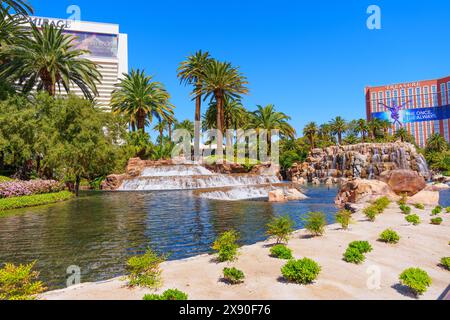 Las Vegas, Nevada - 13 avril 2024 : palmiers et chute d'eau devant les hôtels et casinos Mirage et Treasure Island Banque D'Images