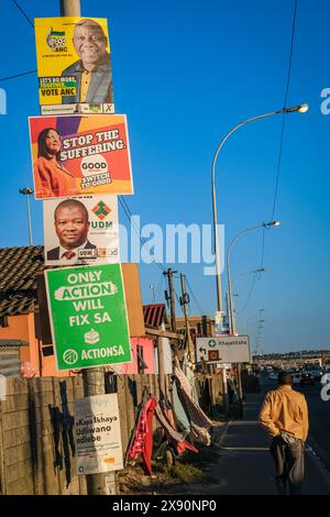 Khayelitsha, affiches électorales pour divers partis se bousculant pour l'espace sur les pôles et les votes des peuples lors des élections de mai 29/2024 en Afrique du Sud. En arrière-plan les cabanes et les toilettes extérieures du canton. Banque D'Images