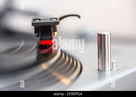 Vue rapprochée d'un disque vinyle en cours de lecture sur une platine avec le stylet en contact. Banque D'Images