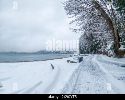 La digue de Vancouver à Third Beach est recouverte de neige, affichant un paysage blanc serein après une forte tempête de neige Banque D'Images