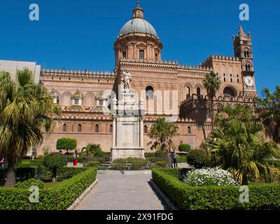 Cathédrale gothique avec grand dôme, sculptures et jardin bien entretenu par temps ensoleillé, cathédrale historique avec des tours contre un ciel bleu, palerme Banque D'Images