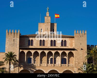 Bâtiment historique avec un drapeau espagnol sur la tour, entouré de palmiers et de remparts, cathédrale historique avec des tours contre un ciel bleu Banque D'Images