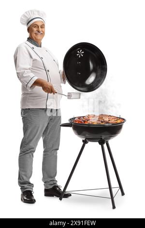 Chef griller la viande sur un barbecue et sourire isolé sur fond blanc Banque D'Images