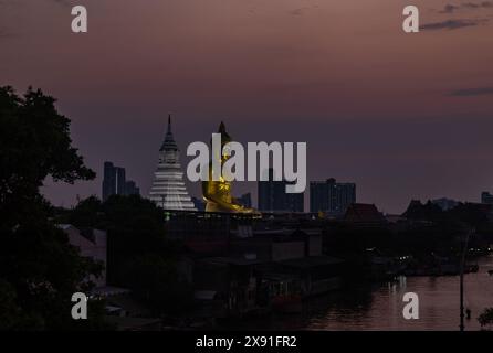 Une image de la grande statue de Bouddha au temple Wat Paknam Bhasicharoen, vue de loin, au coucher du soleil. Banque D'Images