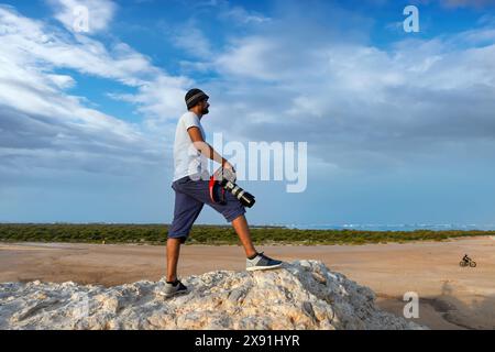 Photographe debout sur une falaise avec un beau paysage de montagne en arrière-plan. Concept de voyage aventure vacances actives en plein air Banque D'Images