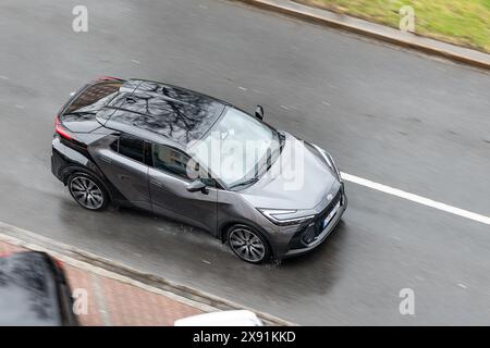 OSTRAVA, RÉPUBLIQUE TCHÈQUE - 23 MARS 2024 : Toyota C-HR AX20 multisegment compact avec effet flou de mouvement sous la pluie Banque D'Images