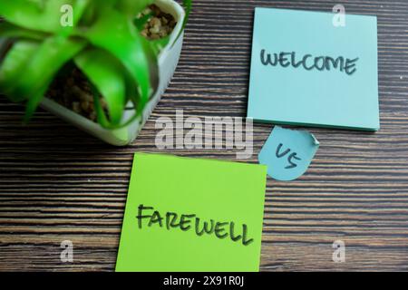 Concept de Bienvenue vs adieu écrire sur des notes autocollantes isolées sur une table en bois. Banque D'Images