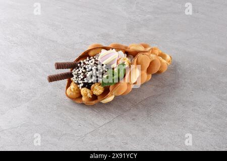Quartier branché de Hong Kong bubble gaufres avec de la crème glacée, de crème et de fruits rouges sur fond de bois blanc. Copy space Banque D'Images