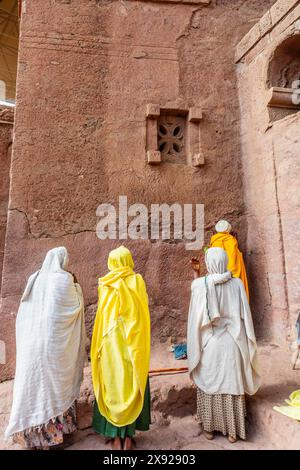 Les femmes pèlerines se sont rassemblées pour le service de masse sur les murs de l'église ortodoxe monolithique taillée dans la roche de Bete Maryam, Lalibela, région d'Amhara, Ethiopie. Banque D'Images