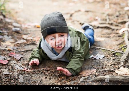 Garçon blessé après être tombé dans la forêt triste et malheureux pleurs enfants Banque D'Images