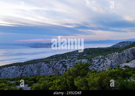 Canal Velebit au coucher du soleil avec les pentes de montagne Velebit, les îles, la mer calme et le ciel étonnant Banque D'Images