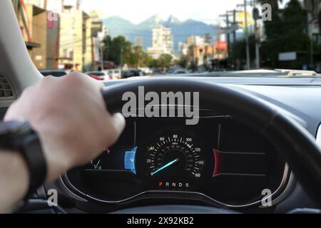 Homme conduisant une voiture moderne sur la rue de la ville, gros plan Banque D'Images