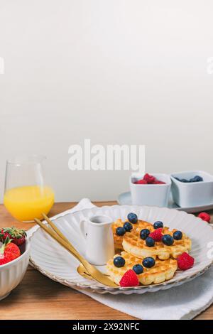 Délicieux petit déjeuner avec gaufres et baies sur la table en bois, vue rapprochée Banque D'Images