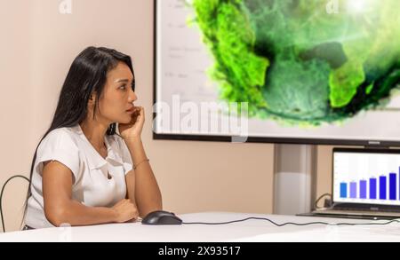 Une jeune femme regarde une présentation environnementale à l'écran Banque D'Images